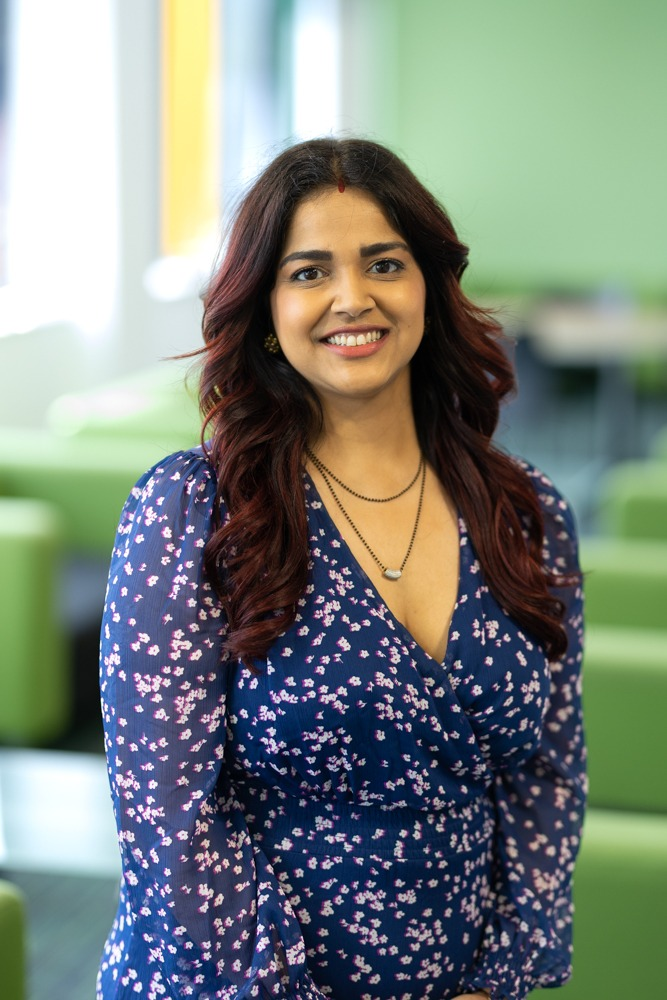 Iraa smiling in a bright office